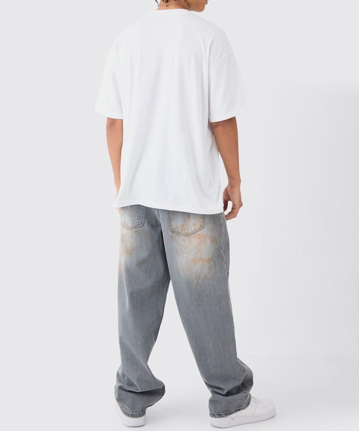 Hyraa Club baggy faded gray denim jeans worn with a white oversized t-shirt and white sneakers